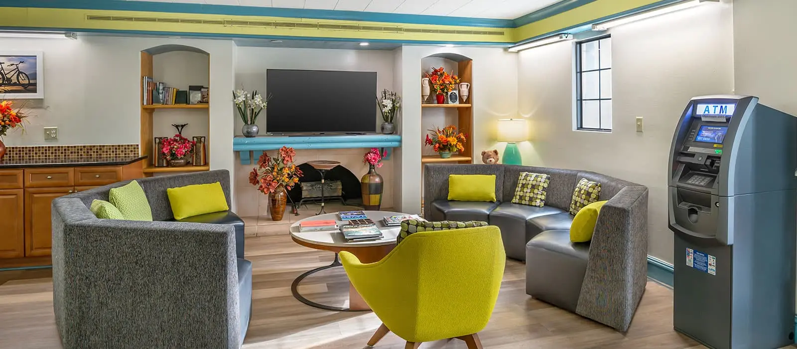 The hotel lobby seating area with armchairs, a fireplace, a television and an on-site ATM